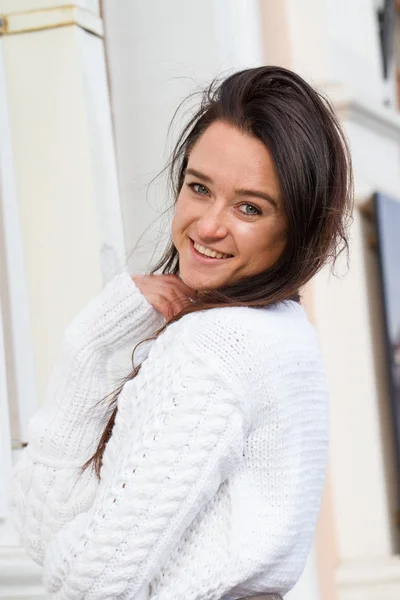 Fiatal lány az építési háttér fehér pulóver — Stock Fotó