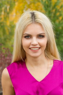 Sarışın sonbahar arka plan üzerinde parlak makyaj ile yaprakları