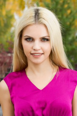 Sarışın sonbahar arka plan üzerinde parlak makyaj ile yaprakları