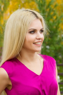 Sarışın sonbahar arka plan üzerinde parlak makyaj ile yaprakları