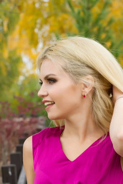 Blonde with bright makeup on the background of autumn leaves — Stock Photo, Image