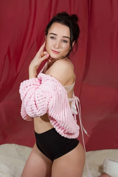 穿着粉红色毛衣的女孩在卧室的床上 — 图库照片