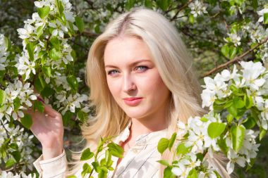 Sarışın bahçede, çiçekli ağaçlar arasında