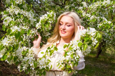 Sarışın bahçede, çiçekli ağaçlar arasında