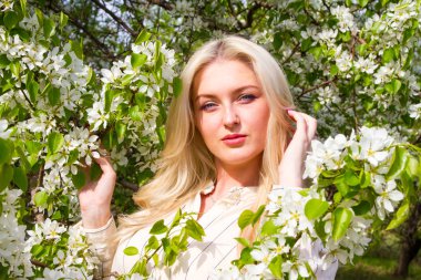 Sarışın bahçede, çiçekli ağaçlar arasında