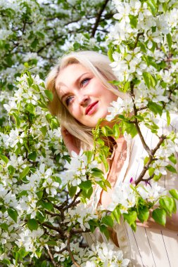 Sarışın bahçede, çiçekli ağaçlar arasında