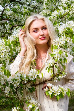 Sarışın bahçede, çiçekli ağaçlar arasında