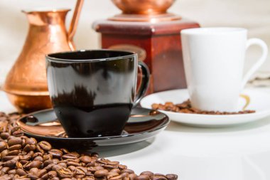 Kahve bardağı yanındaki masada kahve çekirdekleri