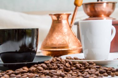 Kahve bardağı yanındaki masada kahve çekirdekleri