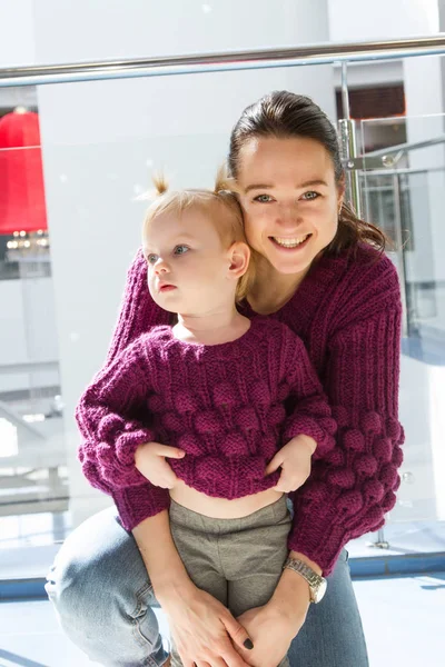 年轻的母亲与她的女儿在购物中心穿着同样的衣服 — 图库照片