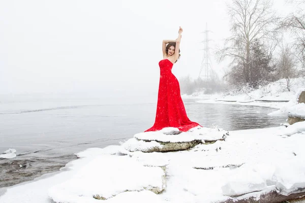 Ung Flicka Lång Röd Klänning Står Snöig Flodstrand Snöfall — Stockfoto