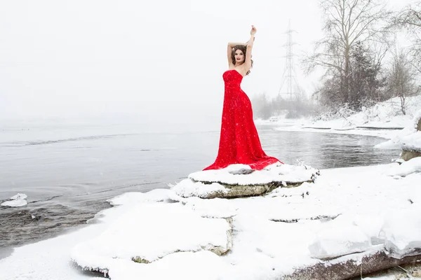 Ung Flicka Lång Röd Klänning Står Snöig Flodstrand Snöfall — Stockfoto