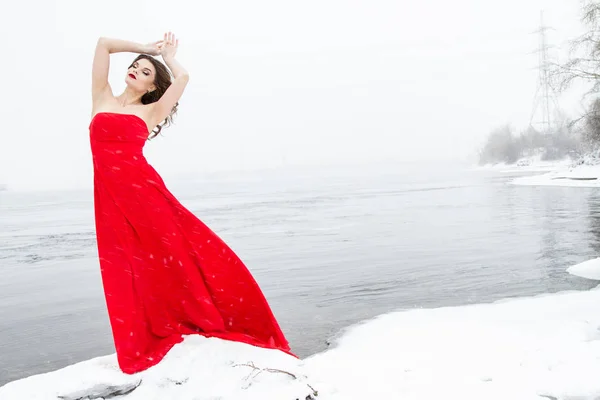 Ung Flicka Lång Röd Klänning Står Snöig Flodstrand Snöfall — Stockfoto