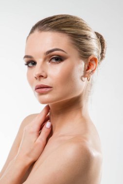 Beyaz arka planda parlak makyajlı genç bir kızın stüdyo portresi.