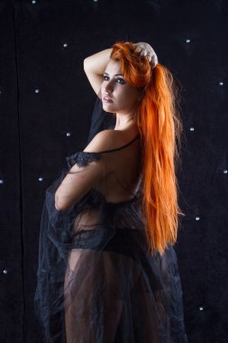 Şeffaf bir pignoirde uzun kızıl saçlı güzel bir genç kız.