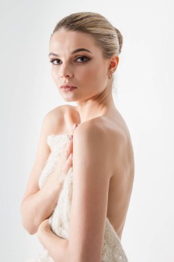 Güzel genç kız çıplak göğüslerini açık bir eşarpla kapatıyor.