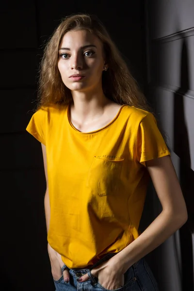 Hermosa Joven Con Una Camiseta Amarilla Pantalones Vaqueros Pie Contra —  Fotos de Stock
