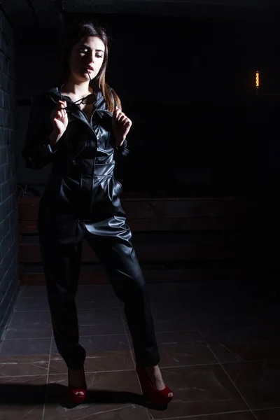 Όμορφη Νεαρή Κοπέλα Μαύρη Δερμάτινη Φόρμα Ένα Σκοτεινό Δωμάτιο — Φωτογραφία Αρχείου