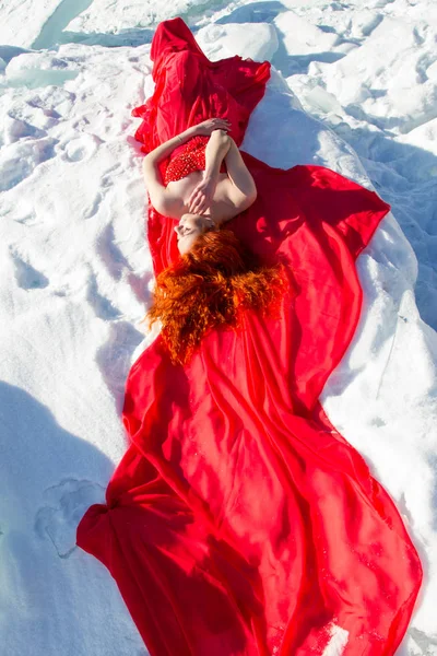 Slender Red Haired Girl Red Dress Lies Snow — Stock Photo, Image