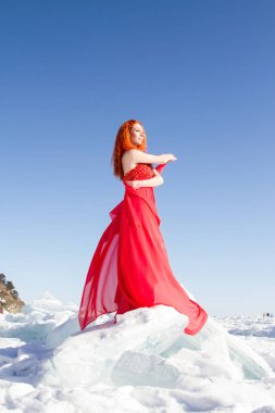 Kırmızı elbiseli kız Baykal Gölü 'nde buz üstünde duruyor.