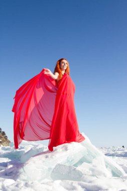 Kırmızı elbiseli kız Baykal Gölü 'nde buz üstünde duruyor.