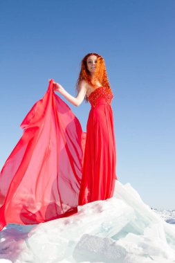 Kırmızı elbiseli kız Baykal Gölü 'nde buz üstünde duruyor.