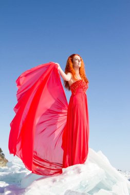 Kırmızı elbiseli kız Baykal Gölü 'nde buz üstünde duruyor.