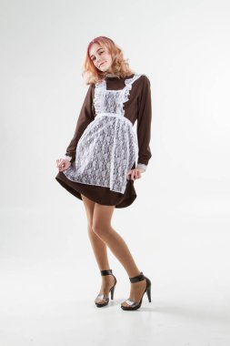 Okul üniformalı bir kız. Beyaz arkaplanda stüdyo portresi.