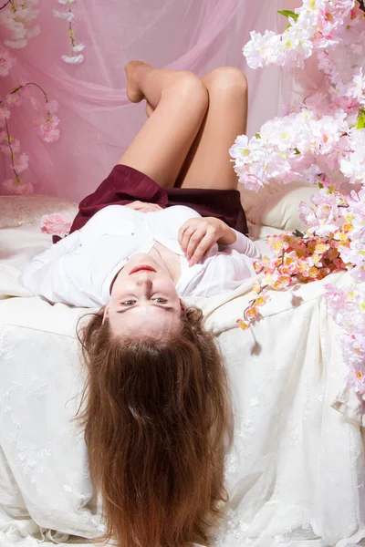 若い女の子は花で飾られたベッドの上に横たわっています — ストック写真