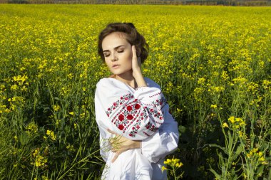 Sarı bir tecavüz alanında nakışlı gömlekli genç bir kız.