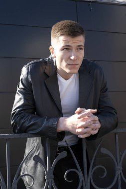 Deri ceketli ve tişörtlü genç adam. Siyah arkaplanda bir portre