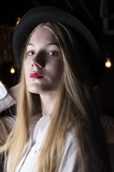 Blonde Black Hat White Shirt Dark Room — Stock Photo, Image