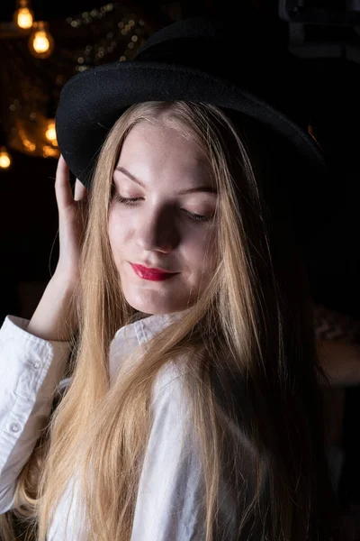 Blonde Black Hat White Shirt Dark Room — Stock Photo, Image