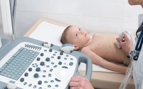Doktor çocuğun karın boşluğunun ultrasonunu yapar.
