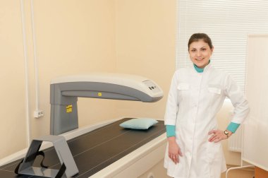 Bir kadın doktor bir mezsitometrenin yanında duruyor. Klinikte densitometri. Tıbbi ekipman