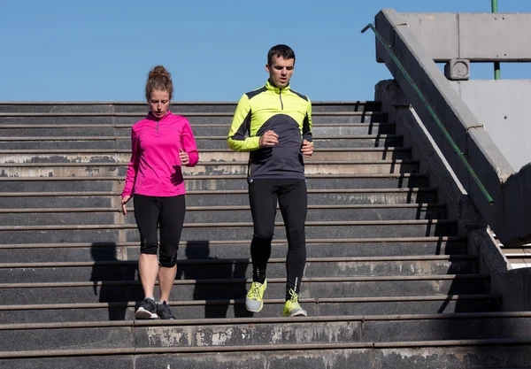 Giovane coppia jogging su gradini — Foto Stock