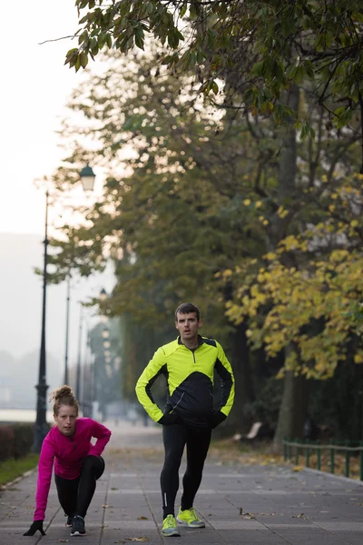 Couple warming up before jogging — Stock Photo, Image