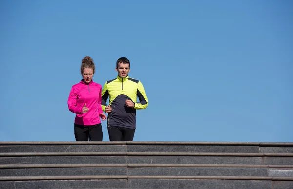 Giovane coppia jogging su gradini — Foto Stock