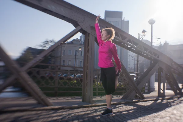 Žena, táhnoucí se před ranní jogging — Stock fotografie