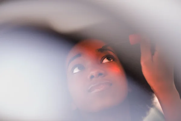 African-American woman doing makeup in the car — Stock Photo, Image