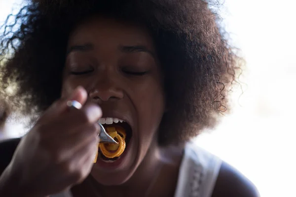 Uma jovem afro-americana comendo massa — Fotografia de Stock
