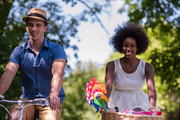 Young multiethnic couple having a bike ride in nature — Stock Photo, Image