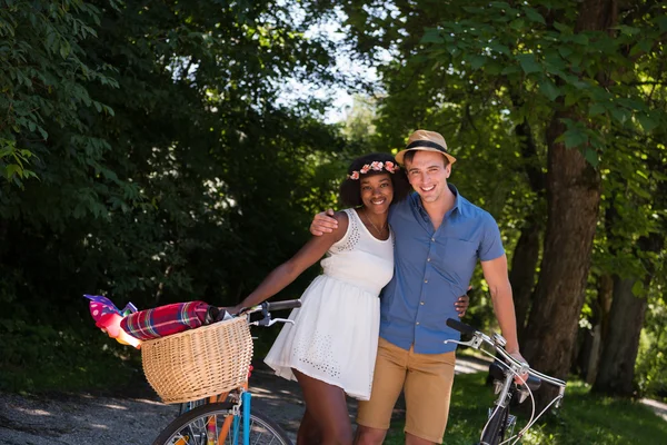 Jovem casal multiétnico ter um passeio de bicicleta na natureza — Fotografia de Stock