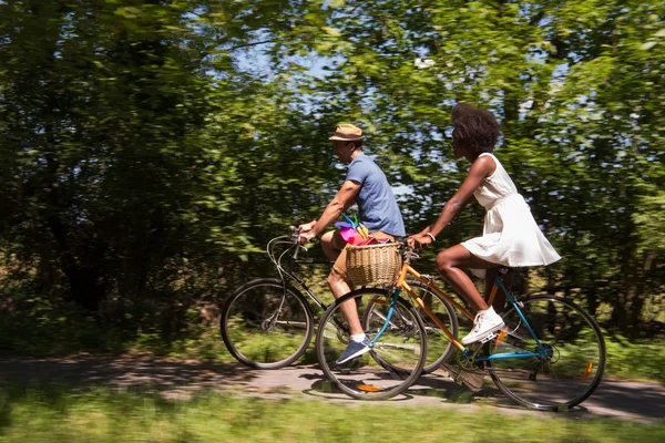 Молода багатоетнічна пара катається на велосипеді в природі — стокове фото