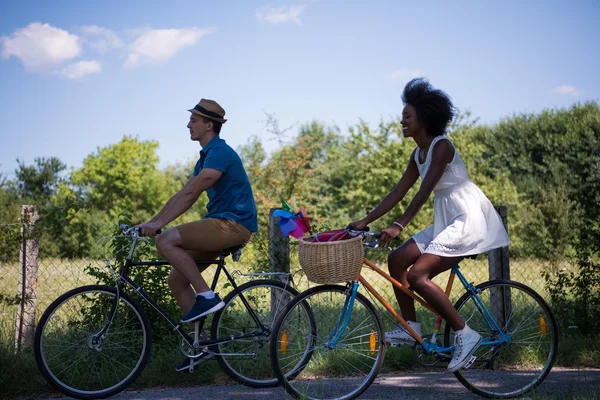 Jeune couple multiethnique faisant une balade à vélo dans la nature — Photo