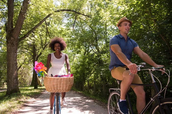 Joven pareja multiétnica teniendo un paseo en bicicleta en la naturaleza —  Fotos de Stock