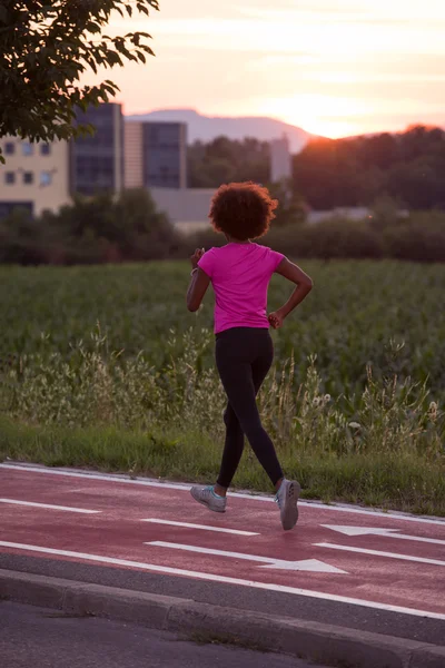 A young African American woman jogging outdoors — Stock Photo, Image