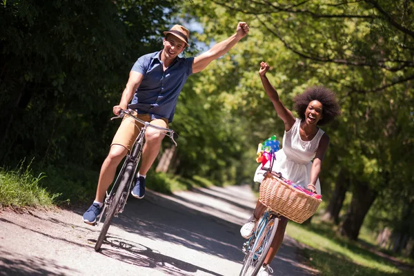 Giovane coppia multietnica che fa un giro in bicicletta nella natura — Foto Stock