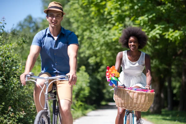 Joven pareja multiétnica teniendo un paseo en bicicleta en la naturaleza — Foto de Stock