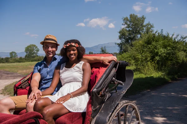 Multiethnisches Paar sitzt in einer Pferdekutsche — Stockfoto